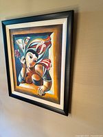 Oblique view of framed painting showing artwork, frame and mat