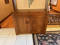 Front view of wood cabinet with cane door panels and brass pulls