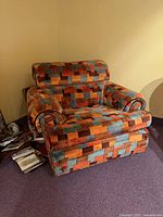 Front angled view of armchair showing fabric pattern and overall condition
