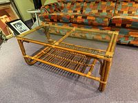 Full view of rattan coffee table with glass top and shelf