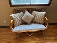 Front view of bamboo rattan loveseat with cushions