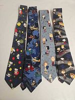 Four Peanuts silk neckties laid out side by side