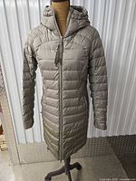 Front view of taupe hooded puffer parka on mannequin