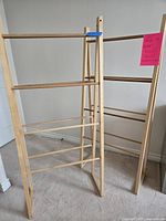 Two freestanding unfinished wood ladder racks standing side by side