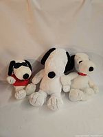 Three Snoopy plush toys side by side