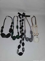 Group shot of all five necklaces laid out side by side