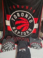 Full lot showing blanket hung as backdrop with tees and sweatpants laid out