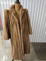 Front view of brown/tan mink fur coat on mannequin showing full length and collar