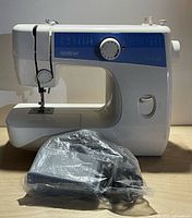 Front view of Brother LS-2125 sewing machine with attached needle area, dial, and pedal in bag
