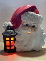 Front view of illuminated blow-mold Santa face and lantern