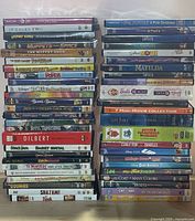 Two tall stacks of assorted DVD movies in cases