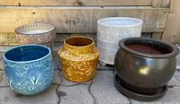 All five ceramic plant pots lined up outdoors