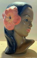 Front-left view of chalkware bust showing facial detail and flower