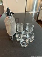 Group shot of all items: soda siphon, four tumblers, two beer mugs