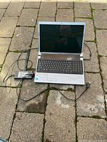 Open Dell 17-inch laptop shown with keyboard, screen and power adapter