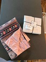 Duvet set package beside folded quilted throw on table