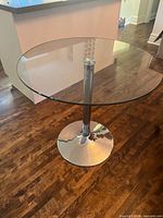 Full view of table showing glass top and chrome pedestal