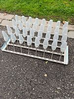 Overall view of IKEA pull-out shoe rack showing plastic shoe holders and metal frame