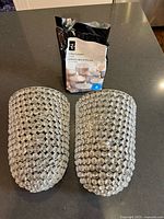 Front view of two beaded wall sconces and bag of tea lights on countertop