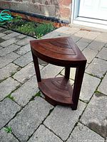 Front angle of teak corner shower bench showing two-tier design