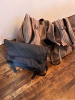 Bellroy black crossbody bag positioned in front of large canvas duffle bag