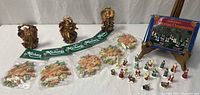 Full lot overview showing angels, sealed Michaels ornaments, boxed Victorian set, loose miniatures