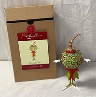 Figurine standing beside original box showing label