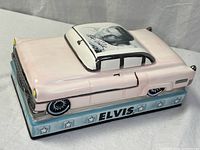 Three-quarter view of ceramic pink Cadillac on base