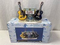 Full set on top of original box showing two ceramic guitar shakers and stage display