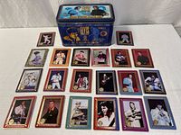 Overall view of blue tin and 20 metallic Elvis cards laid out