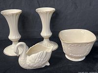 Group shot of all four Lenox ivory porcelain pieces: two fluted vases, swan dish, square footed bowl