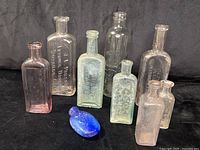 Group shot showing all nine bottles with varying sizes and colors