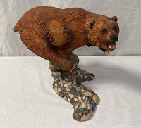 Full view of resin grizzly bear on pebble stream base