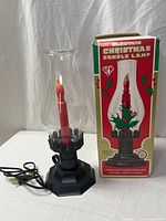 Lamp unlit beside original box showing branding and parts