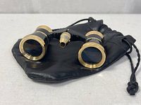 Opera glasses front view resting on pouch
