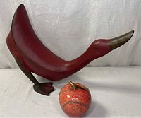 Wooden duck sculpture side view with ceramic apple
