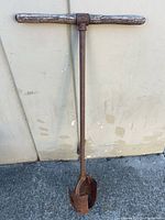 Full view of digger showing wood handle, cast iron shaft and clamshell blades