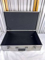 Open silver aluminum case showing interior and lid foam