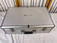 Closed silver aluminum carry case top view showing logo
