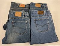 Four folded Levi’s jeans showing back pockets and waistband patches