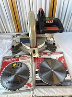 Miter saw with guard up, Jet logo visible, two packaged Diablo blades in front