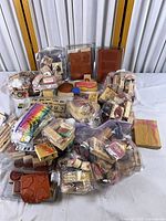 Wide view of entire lot spread on table, showing numerous wood stamps, clamshell cases, loose rubber sheets