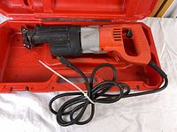 Saw inside open red Milwaukee case showing full tool and cord
