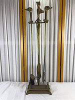 Full view of brass fireplace tool set on stand