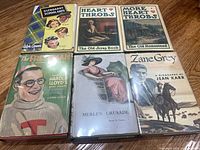 Six books with dust jackets arranged on floor