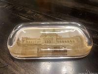 Front view of glass paperweight showing embedded building photograph