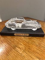 Glass Jaguar E-Type on wood base, side view with nameplate visible