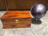 Closed cedar box beside mini globe