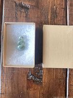 Pendant in open box with lid beside