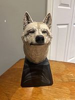 Front view of wolf head sculpture on base